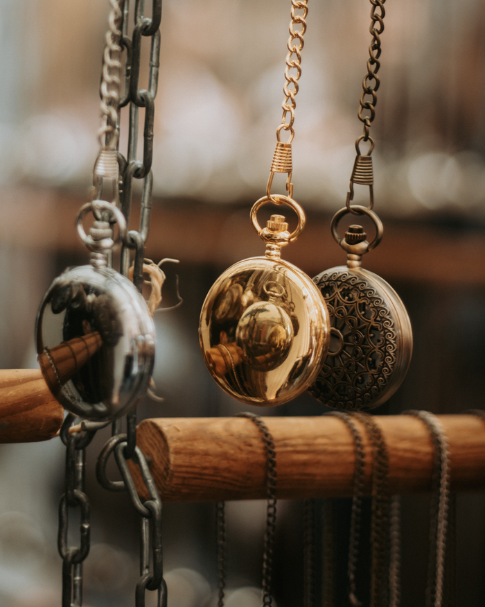 Elegant vintage pocket watches hanging in a market stall in Madrid, Spain.